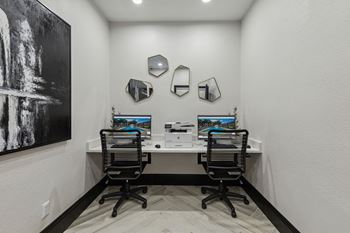 A home office with two desks and two computer monitors